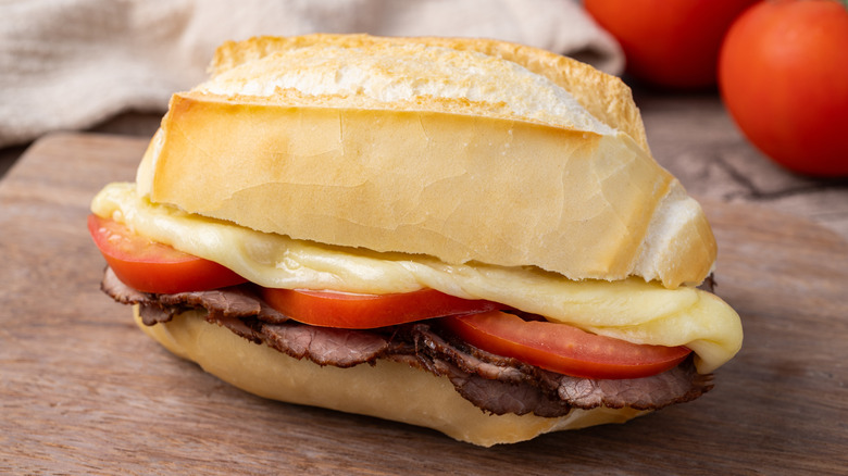 A bauru sandwich on a wooden cutting board