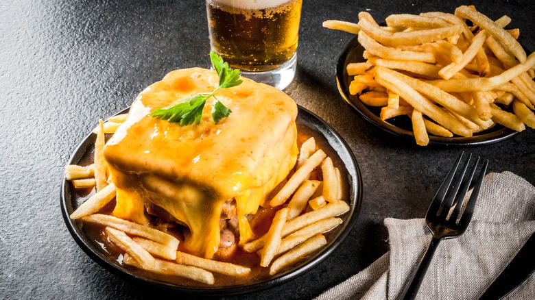 A Francesinha sandwich on a plate with fries