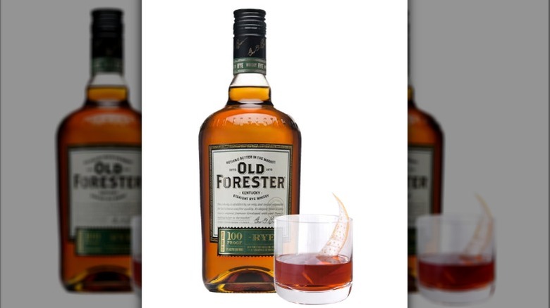 A bottle of Old Forester Rye 100 next to a glass