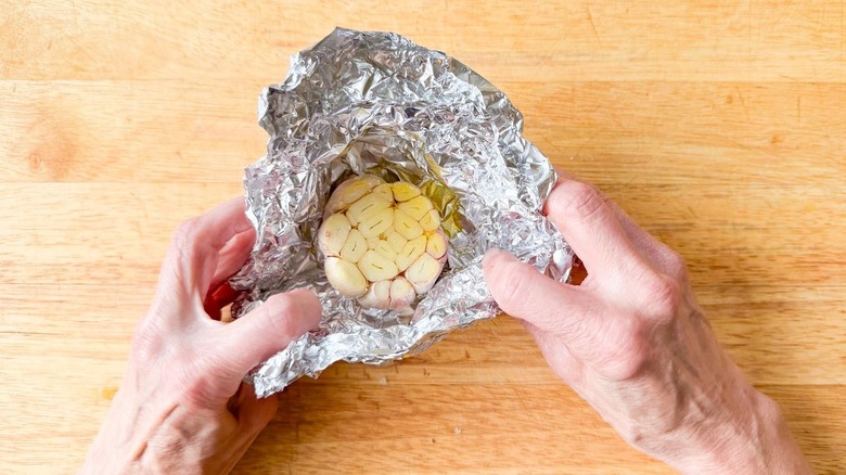 Sliced garlic head with olive oil in foil
