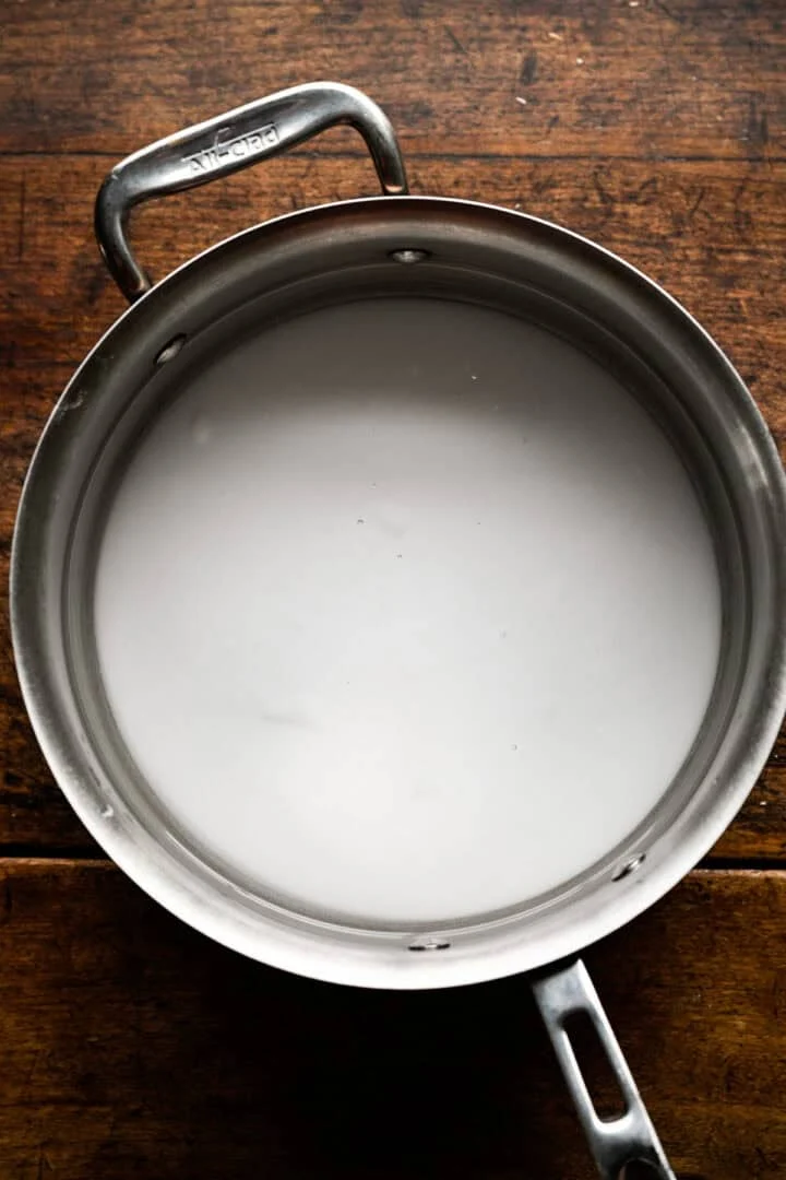 Cloudy baking soda and water solution in a stainless steel saucepan.