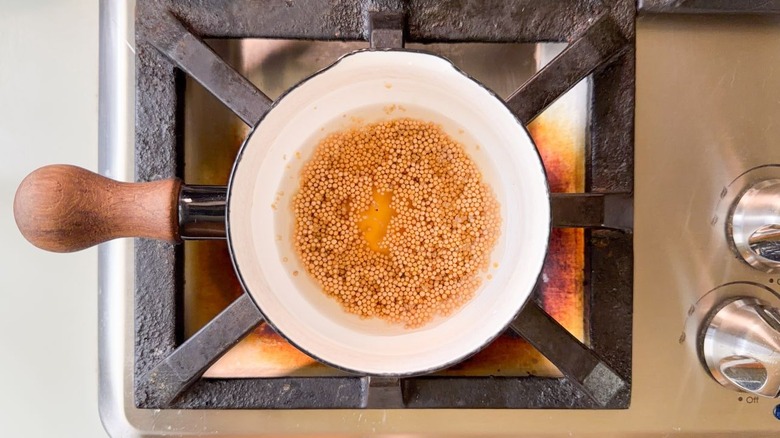 Dry mustard seeds in small saucepan with apple cider vinegar, maple syrup, and water