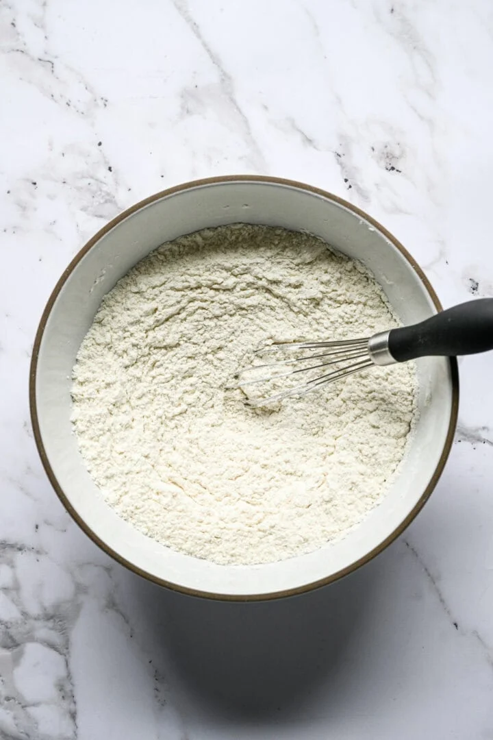 Flour, cornstarch and salt being whisked together in a large bowl.