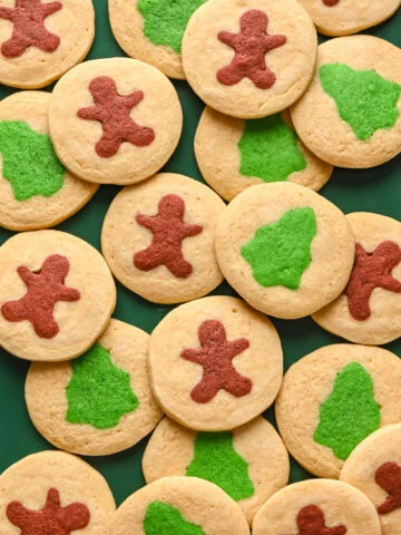 Gingerbread cookies with holiday shapes on green tray for Christmas celebration.