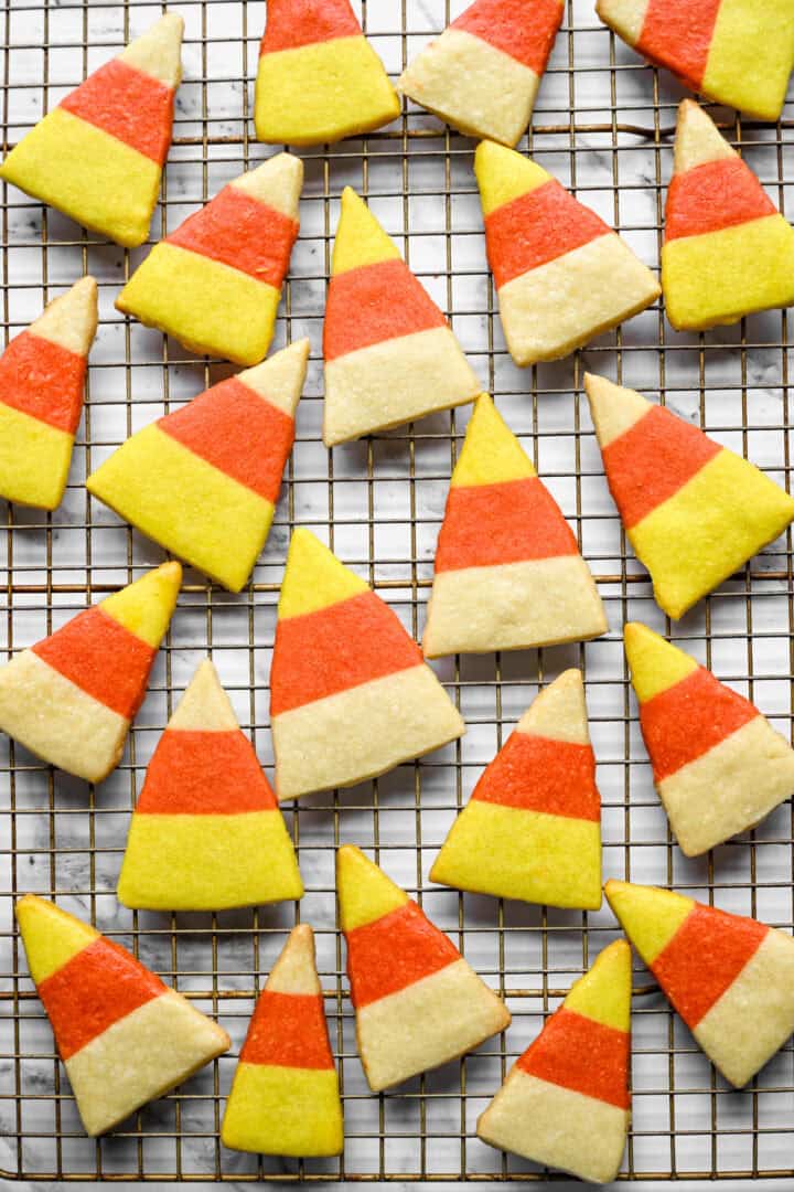 Overhead view of a wire cooling rack covered with baked candy corn shortbread cookies.