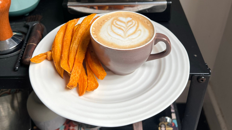 A latte is paired with sweet potato fries.