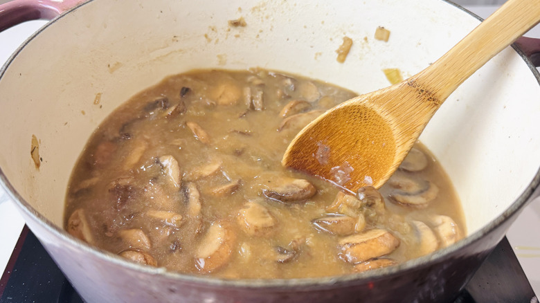 Mushrooms in brothy mixture in Dutch oven