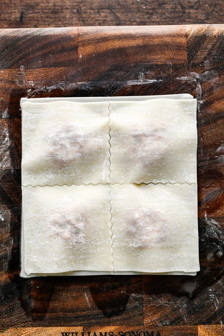 Two sealed egg roll wrappers cut into four square pizza rolls with wavy edges.
