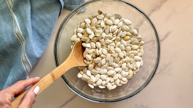 Raw pumpkin seeds in bowl with vinegar