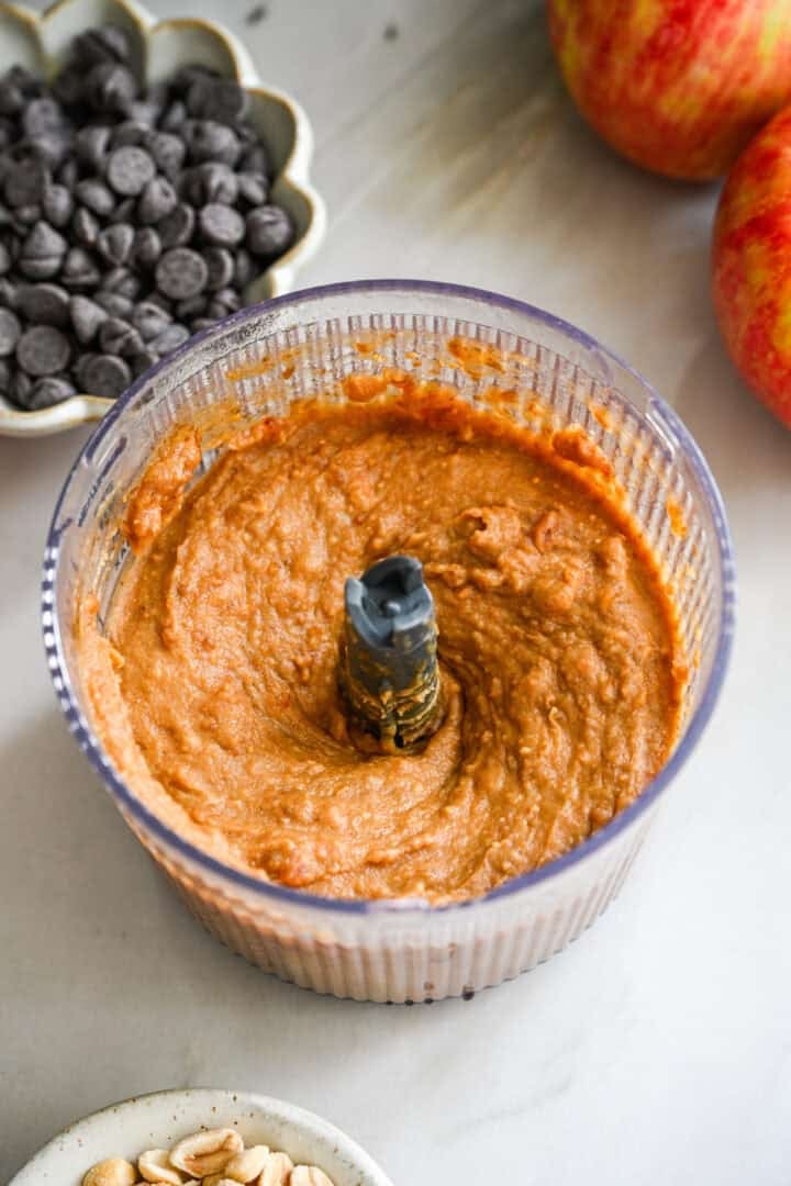 45 degree view of smooth peanut butter date spread in a small food processor.