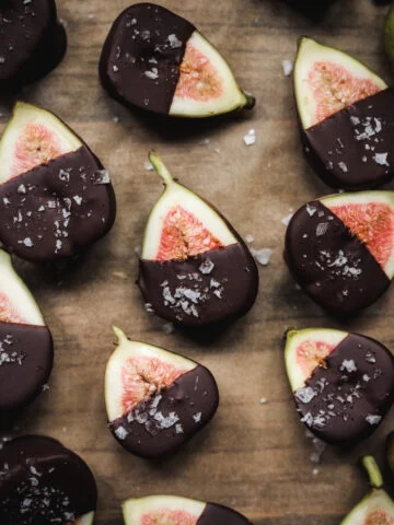 Overhead view of halved figs dipped in dark chocolate and sprinkled with sea salt.