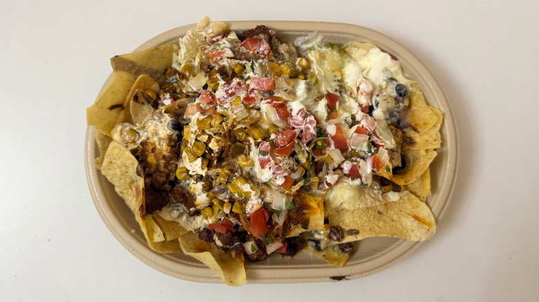 Moe's Nachos with various toppings on white table