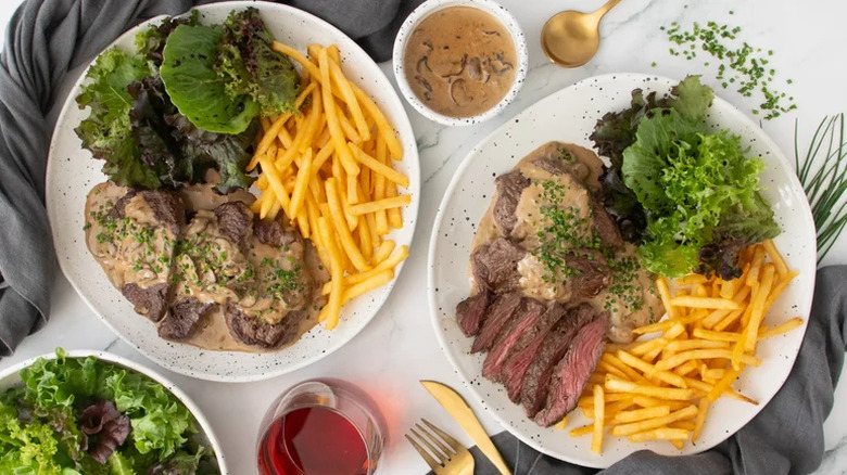 Old-School Steak Diane served with fries, served on white plates