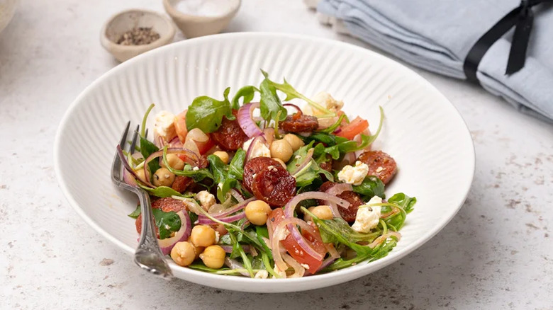 Chorizo chickpea salad with feta served in a white bowl