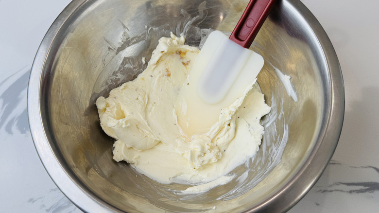 Cream cheese mixture with rubber spatula in bowl