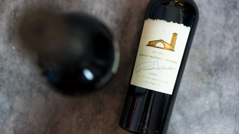 A bottle of Cabernet Sauvignon on a gray surface.