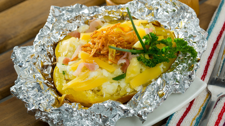 A cheesy baked potato with crispy fried onions.