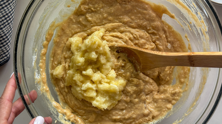 Mashed banana in bowl with peanut butter waffle batter