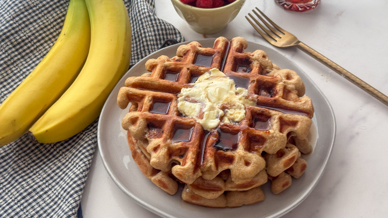 Stack of waffles topped with syrup and butter