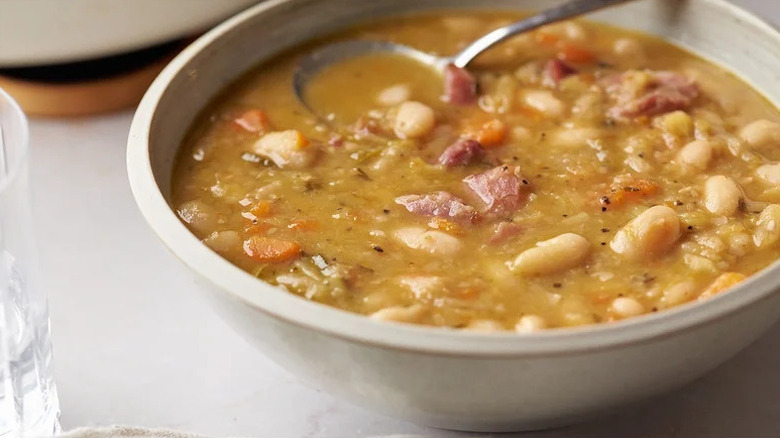 Bowl of ham and bean soup with a spoon