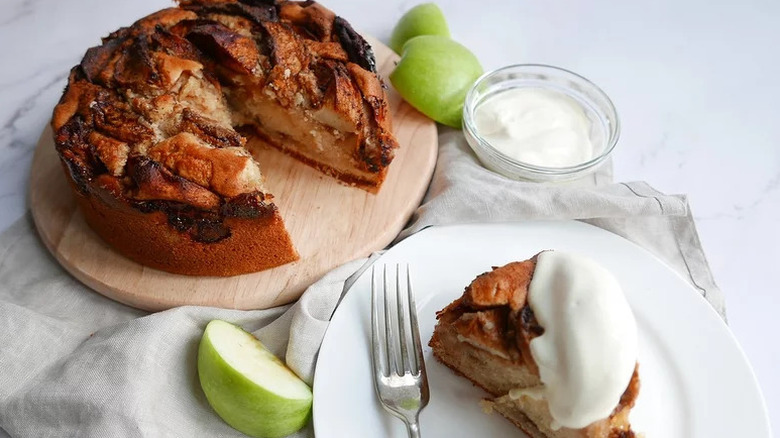 Spiced apple cake with a slice on a white plate