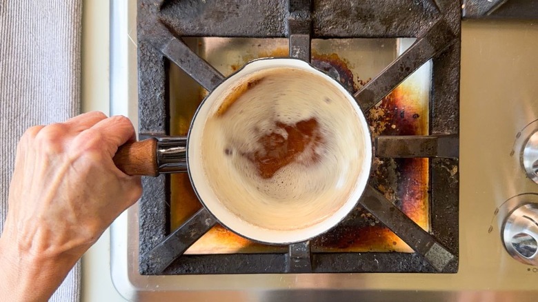 Swirling brown butter in saucepan on stovetop