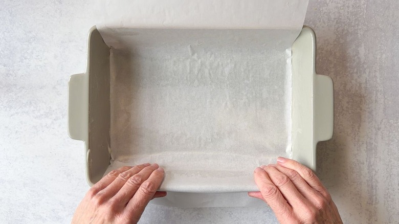 Lining a baking dish with parchment paper that has an overhang on 2 sides