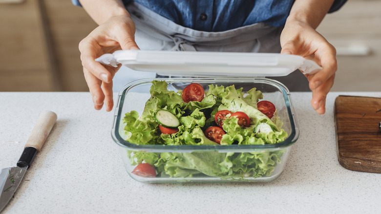Person packaging food in storage container