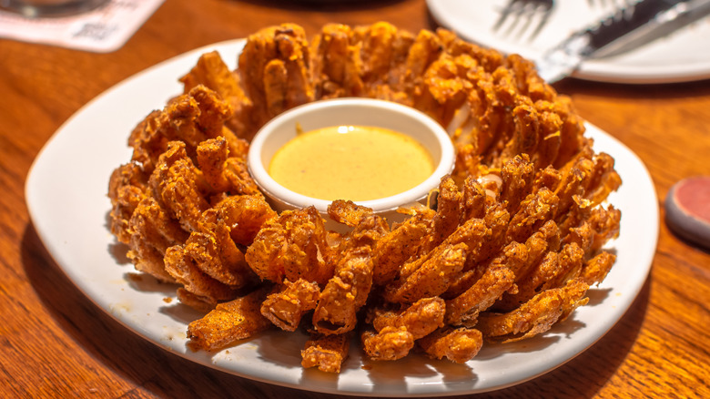 Fried Bloomin' Onion on a plate with dipping sauce