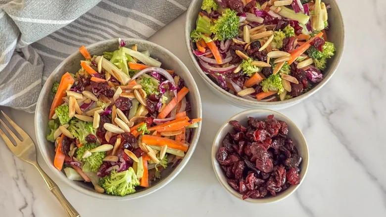 Two bowls of Sweet And Savory Broccoli Slaw with craisins