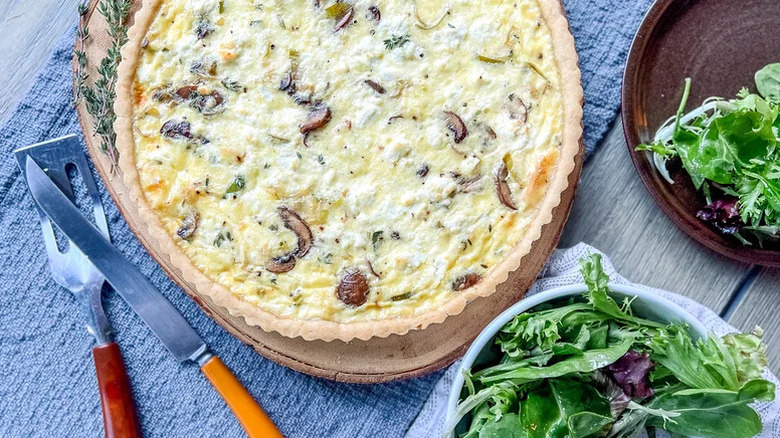 Freshly baked Mushroom And Leek Quiche with fresh mixed greens on the side