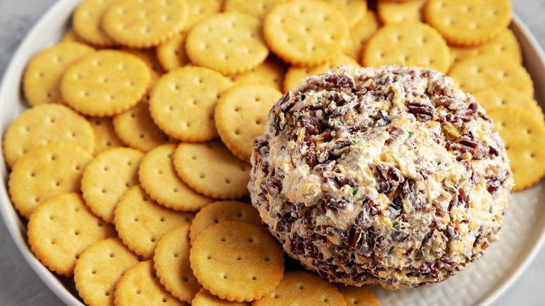 A cheese ball is served with crackers