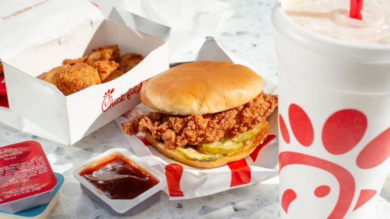 Chick-Fil-A sandwich sitting beside a drink and box of nuggets