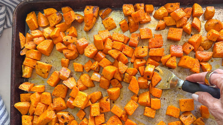 hand flipping sweet potatoes