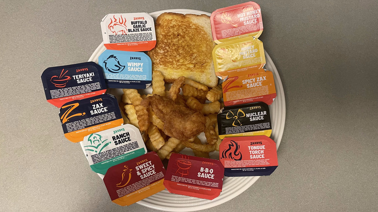 All 12 Zaxbys sauces on a plate with Texas toast, crinkle-cut fries, and a chicken tender.