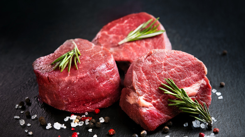 Three uncooked filed mignon steaks.
