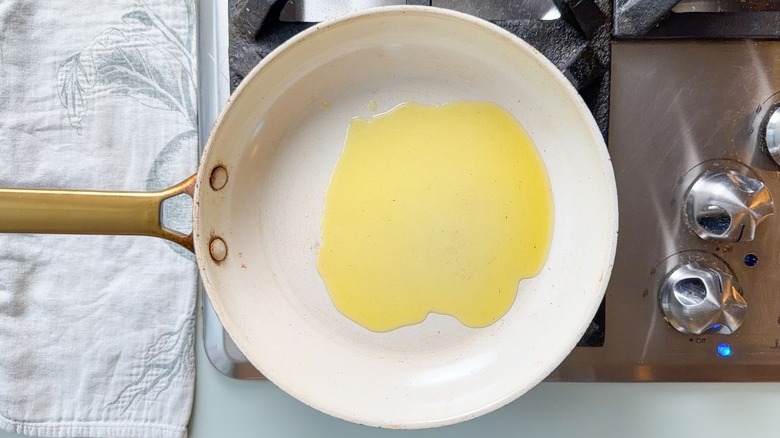 Olive oil in white skillet on stovetop