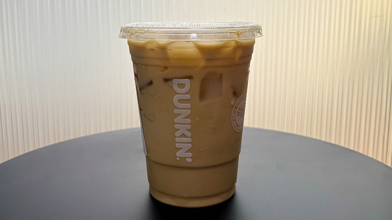 Small Dunkin' Nutty Pumpkin Iced Protein Latte on a black table